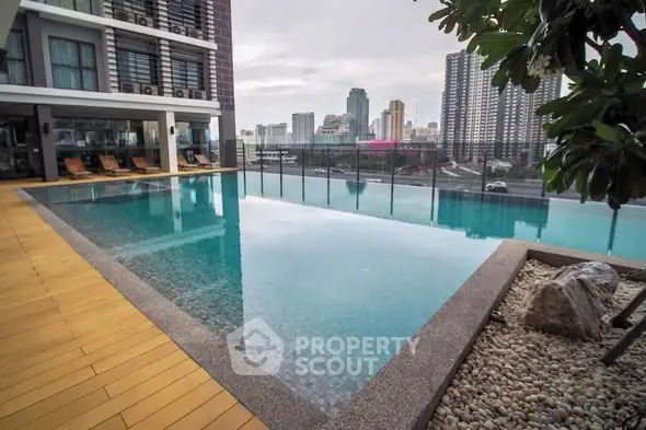 Luxurious rooftop pool with stunning city skyline views in modern high-rise building.