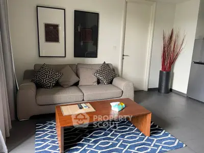 Modern living room with stylish sofa and geometric rug in a cozy apartment setting.