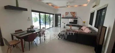 Spacious modern living room with sleek design and large windows offering abundant natural light.