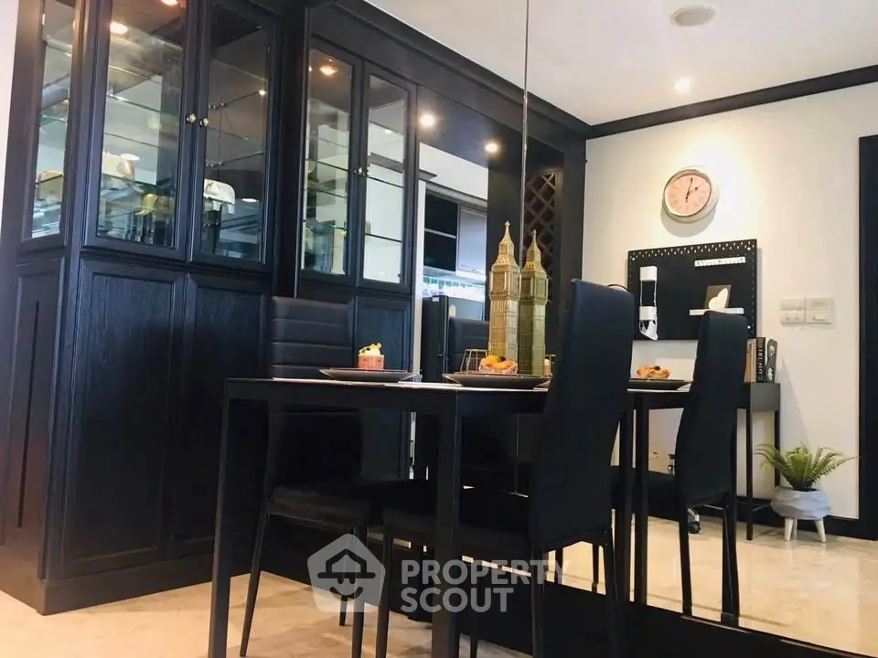 Elegant dining area with black furniture and glass cabinet in modern home
