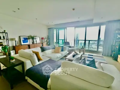 Spacious modern living room with large windows and city view, featuring stylish furniture and decor.