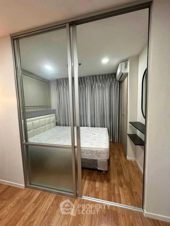 Modern bedroom with sliding glass doors and wooden flooring