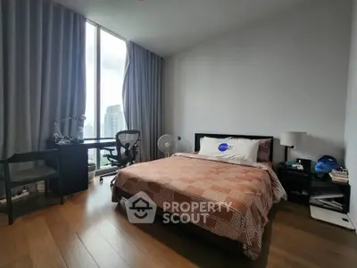 Spacious bedroom with city view, featuring a cozy bed, work desk, and modern decor.