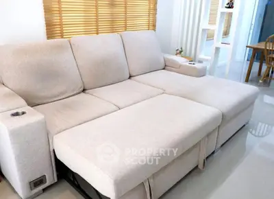 Spacious modern living room with comfortable beige sectional sofa and stylish decor