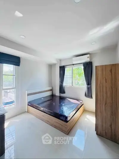 Bright and airy bedroom with large windows and modern furnishings in a stylish apartment.