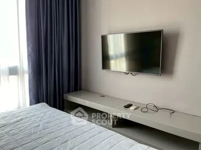 Modern bedroom with wall-mounted TV and sleek furniture