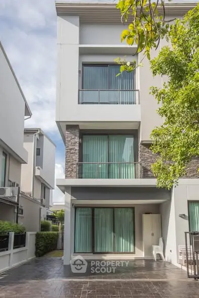 Modern multi-story residential building with large windows and a sleek facade.