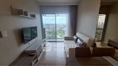 Modern living room with balcony and city view, featuring sleek furniture and natural light.