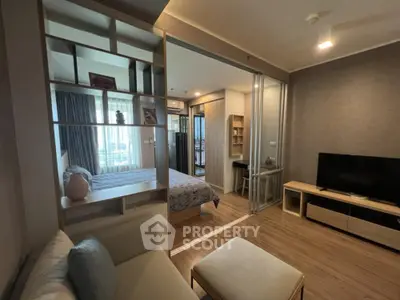 Modern apartment with open living room and bedroom, featuring stylish decor and natural light.