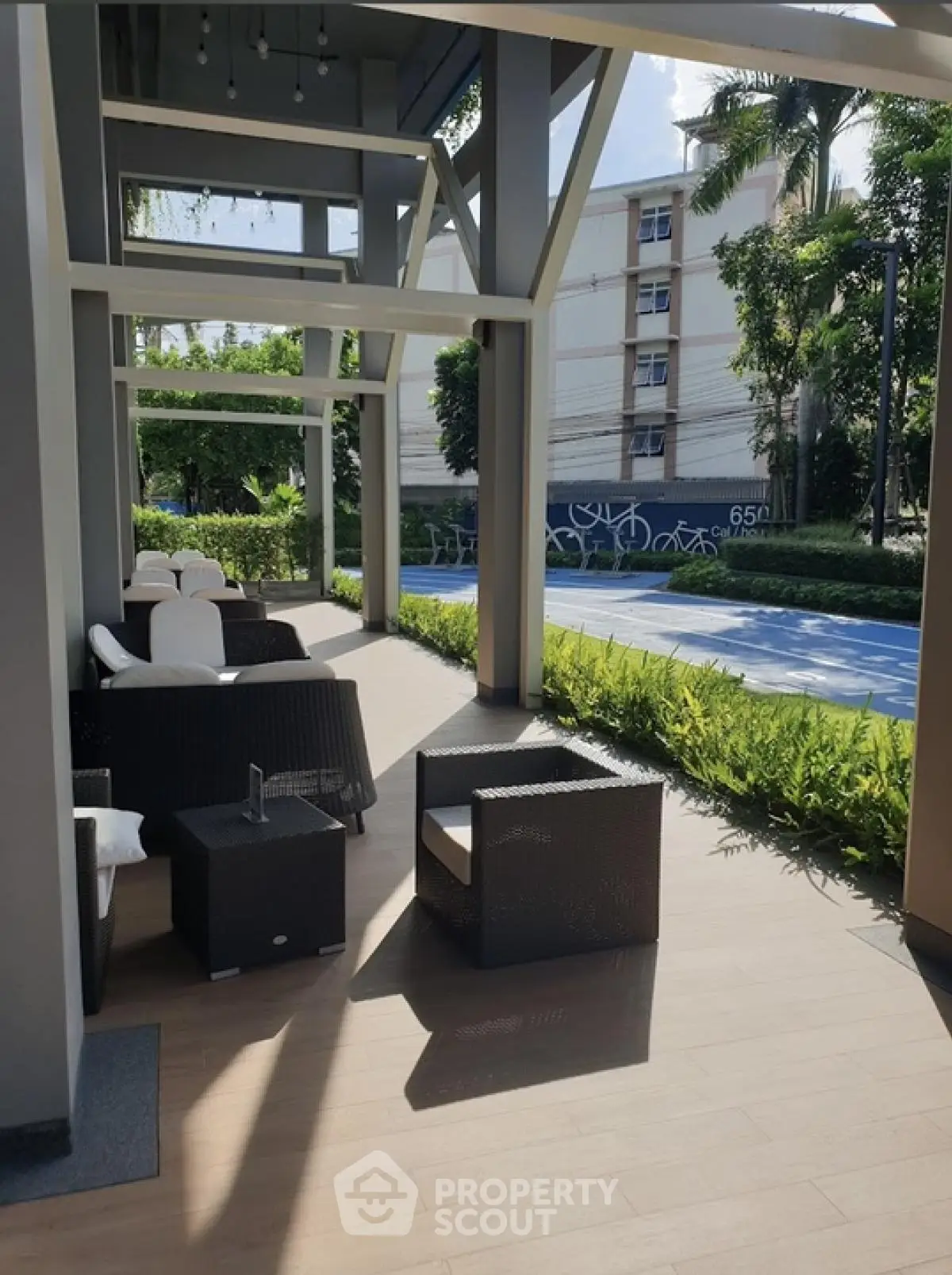 Chic outdoor seating area with modern furniture and lush greenery in a serene setting.