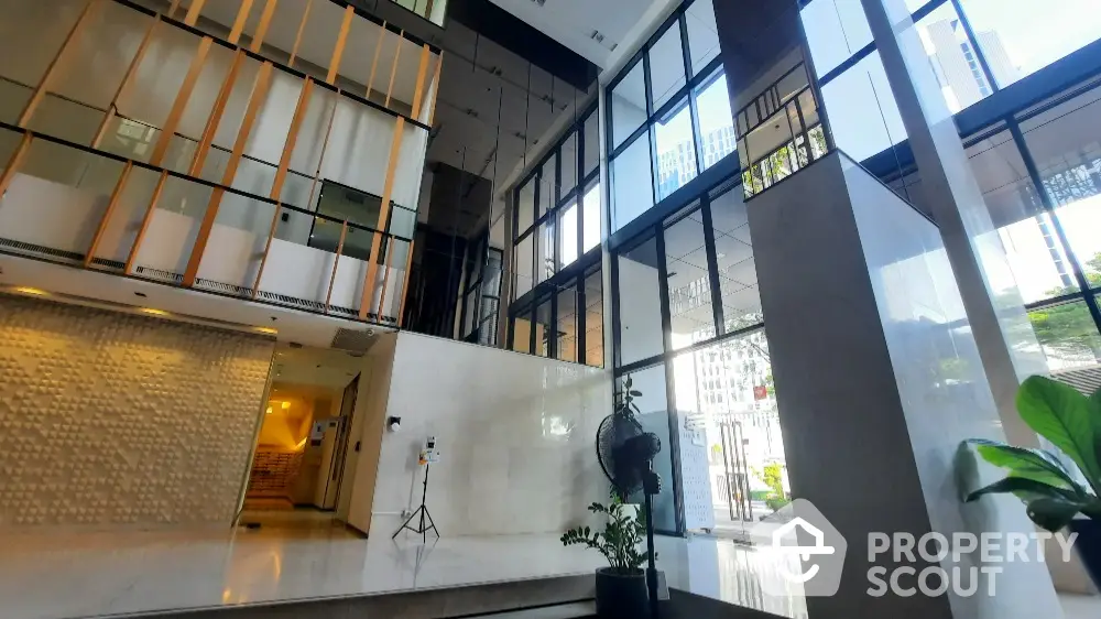 Luxurious modern building entrance with high ceilings and glass walls