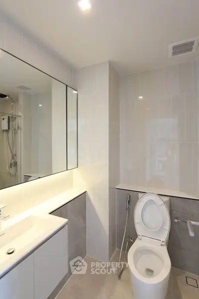 Modern bathroom with sleek fixtures and elegant tiling, featuring a spacious shower and contemporary design.