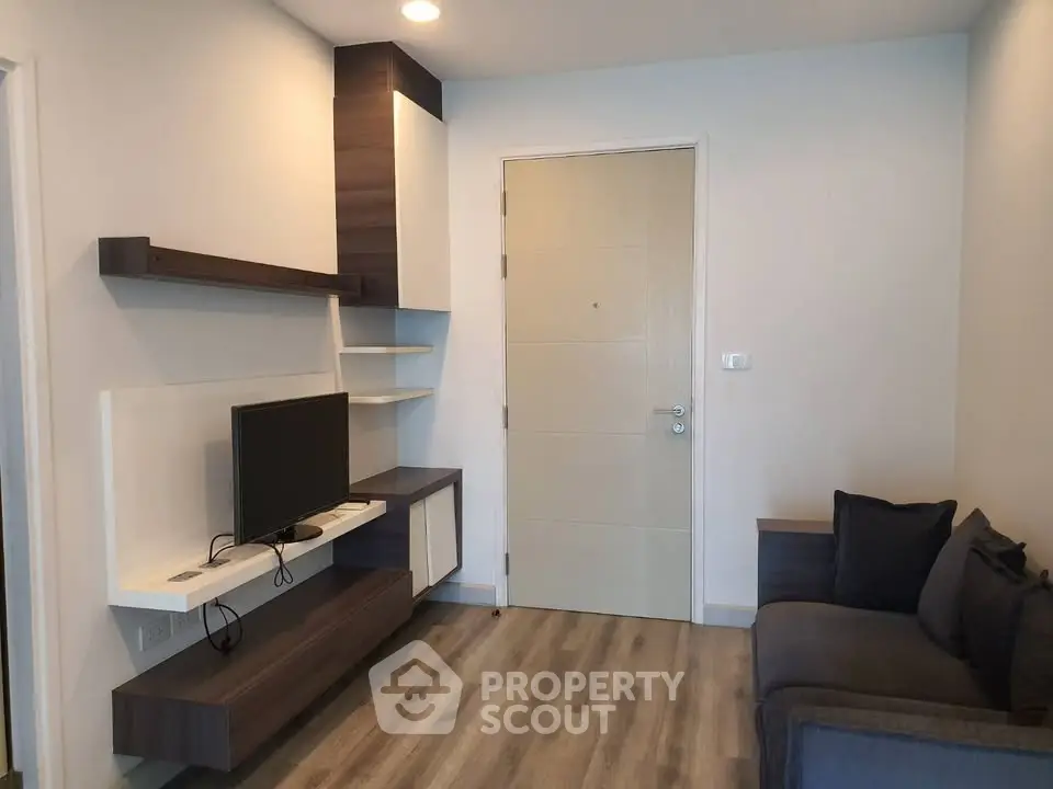 Modern living room with sleek TV unit and cozy sofa in stylish apartment.