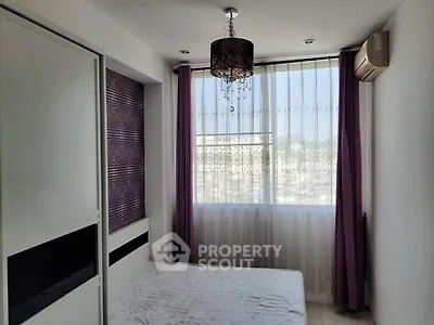Bright bedroom with large window and modern chandelier