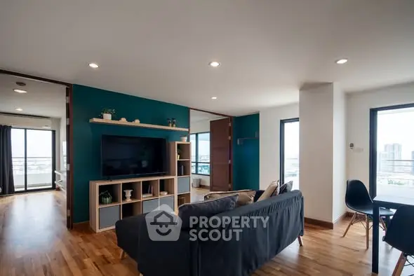 Spacious modern living room with stylish decor and city view, perfect for urban living.