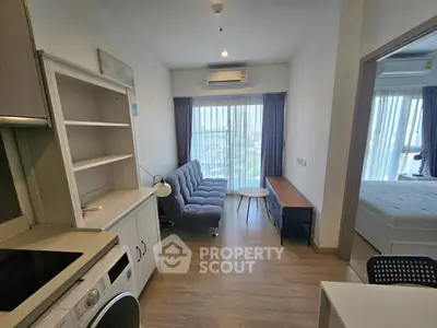 Modern apartment interior with open layout, featuring a cozy living area and a glimpse of the bedroom.