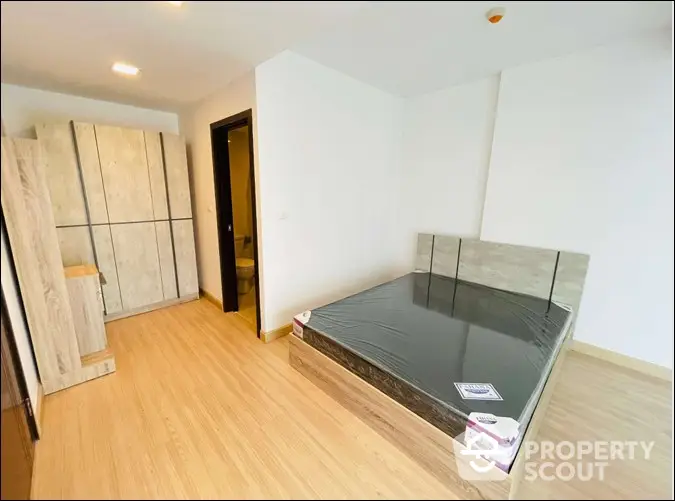 Modern bedroom with wooden flooring and sleek furniture in a bright apartment