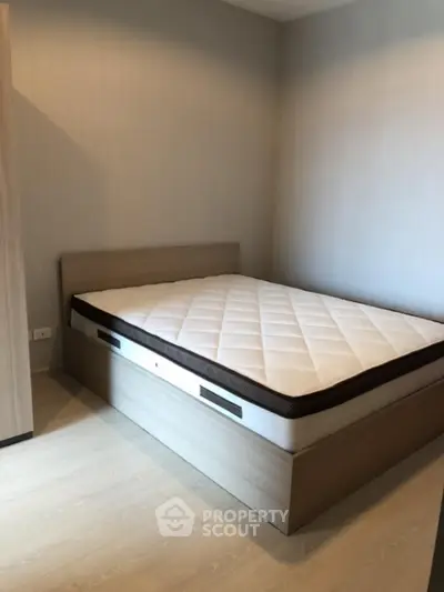 Modern minimalist bedroom with wooden bed frame and comfortable mattress