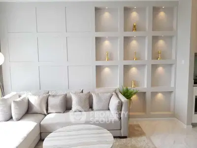 Elegant living room with modern sectional sofa and decorative wall niches.