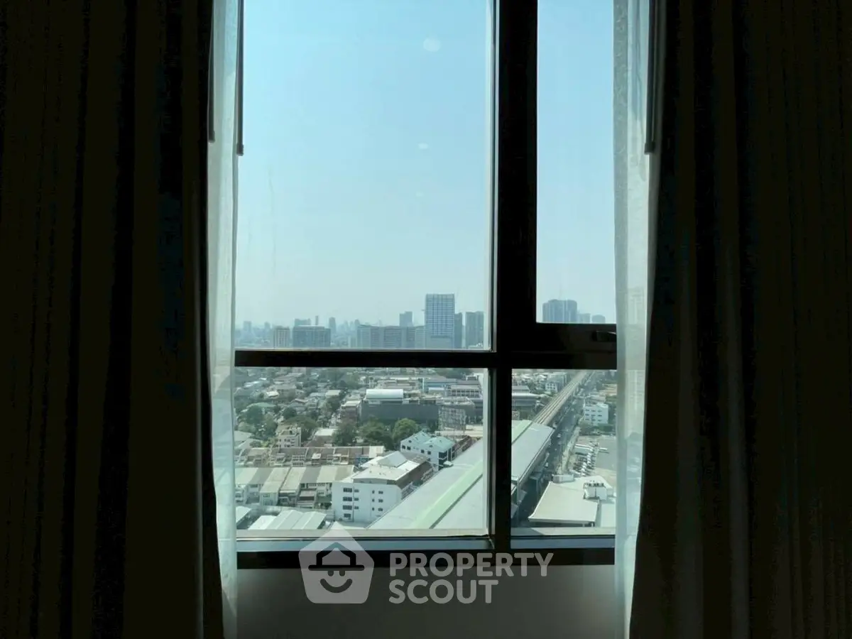 Stunning cityscape view from high-rise apartment window with curtains.