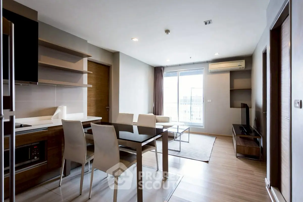 Modern living room with dining area and large window view in a stylish apartment.