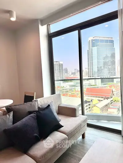 Modern living room with city view and stylish furniture in high-rise apartment.