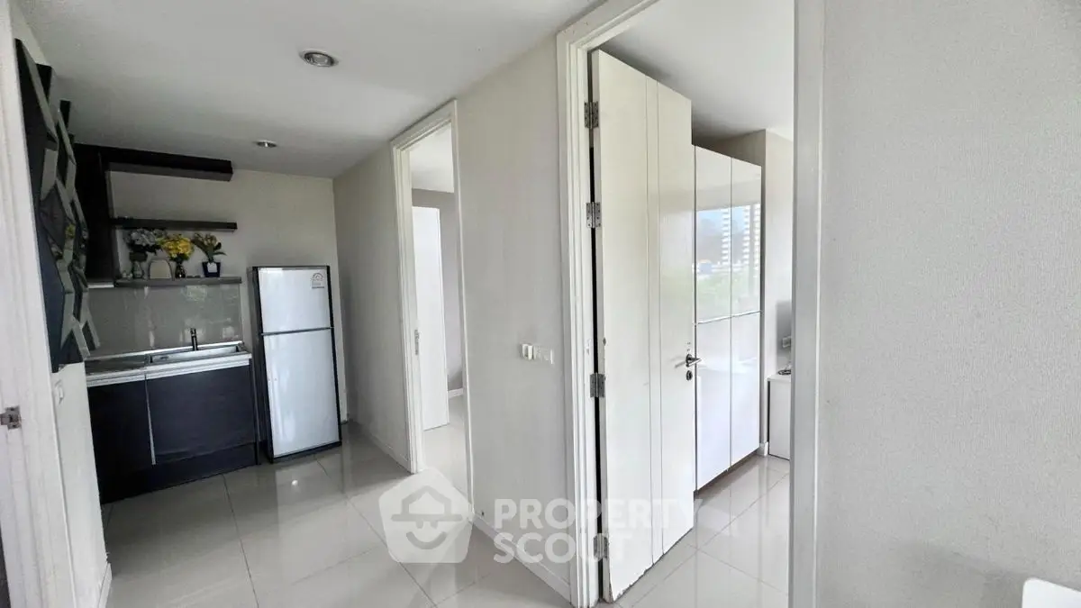 Modern apartment hallway with sleek kitchen and ample natural light