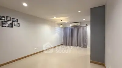 Spacious empty room with modern lighting and large window, ideal for customization.
