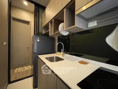 Modern compact kitchen with sleek cabinetry and built-in appliances