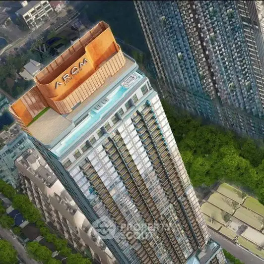 Stunning aerial view of a modern high-rise building with rooftop pool and lush surroundings.