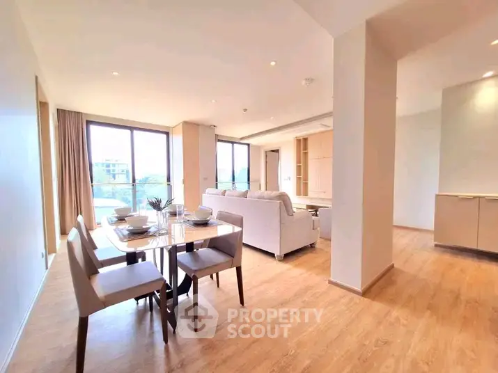 Spacious modern living room with dining area and large windows offering natural light.