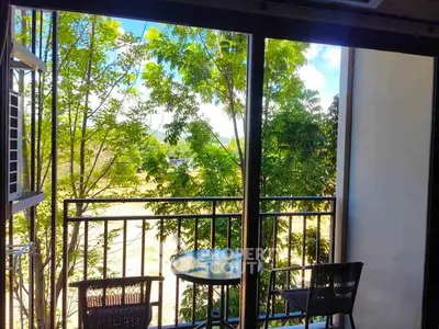 Charming balcony with lush green view and cozy seating area.