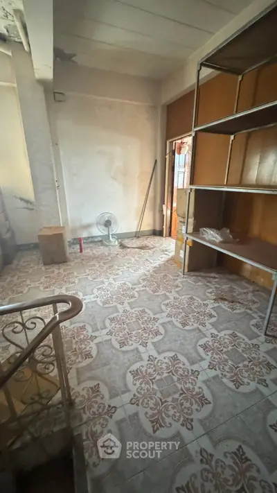 Spacious storage room with tiled floor and metal shelving unit, ideal for organization.