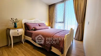 Elegant bedroom with stylish decor and large window offering natural light