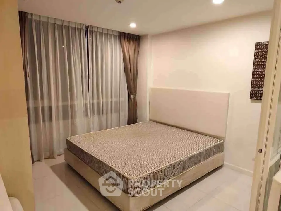 Modern bedroom with large window and minimalist decor in a stylish apartment.