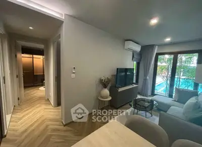 Modern living room with pool view, stylish decor, and natural light.