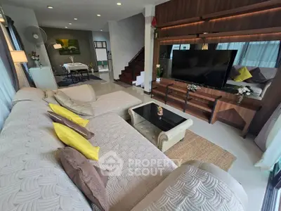 Spacious modern living room with large sectional sofa and entertainment center