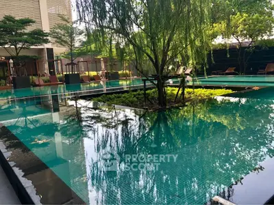 Luxurious outdoor pool area with lush greenery and serene ambiance in a modern residential complex.