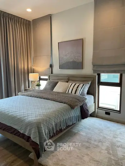 Cozy bedroom with stylish decor and natural light, featuring a comfortable bed and elegant curtains.