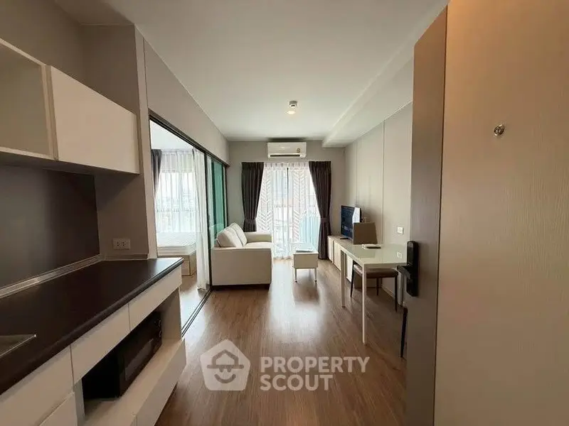 Modern living room with open kitchen and balcony view in stylish apartment