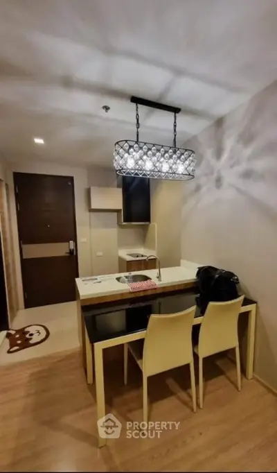 Modern kitchen with stylish lighting and dining area in a cozy apartment.