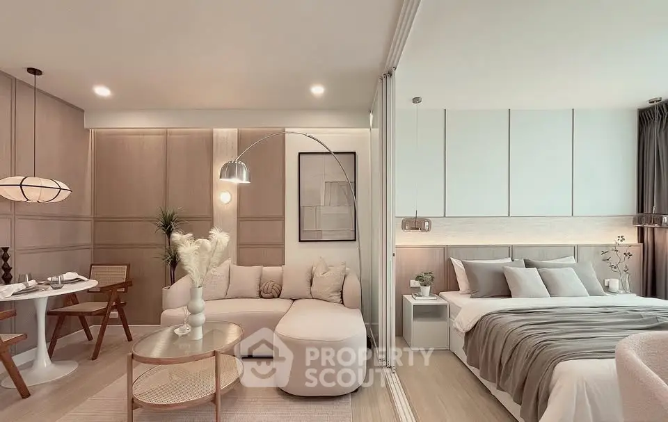 Modern open-plan living room and bedroom with elegant decor and neutral tones.