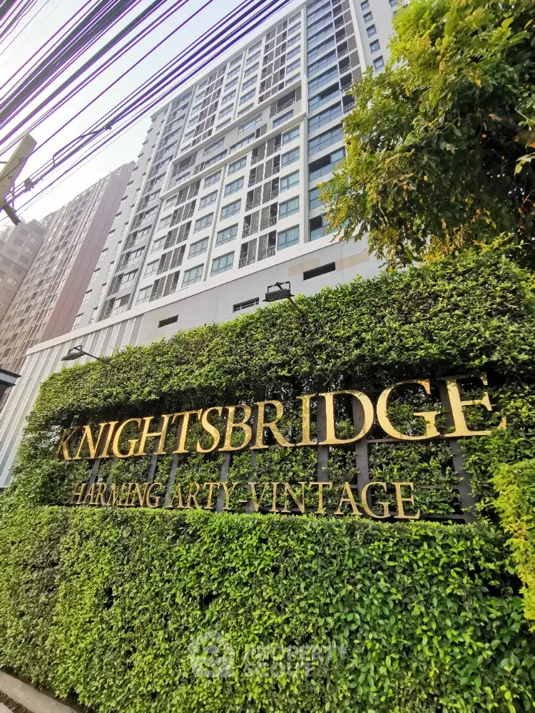 Modern high-rise building exterior with lush greenery and Knightsbridge sign