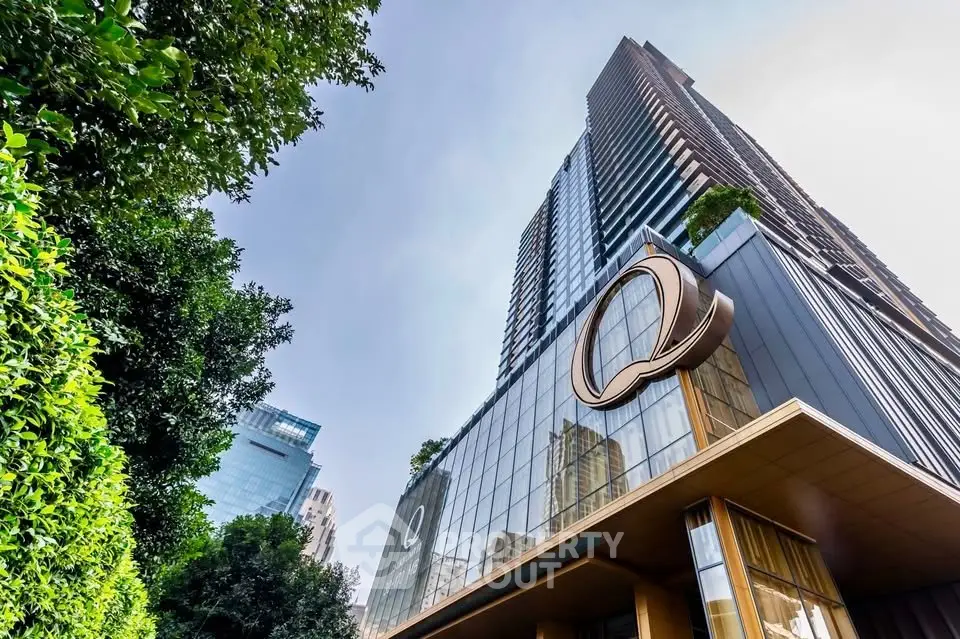 Stunning modern high-rise building with sleek glass facade and lush greenery.