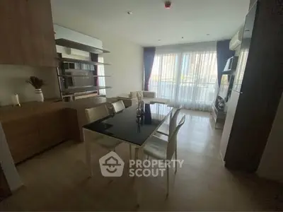 Modern living room with dining area and large windows in a stylish apartment.