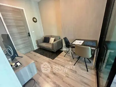 Modern living room with cozy seating and stylish decor in a compact apartment.