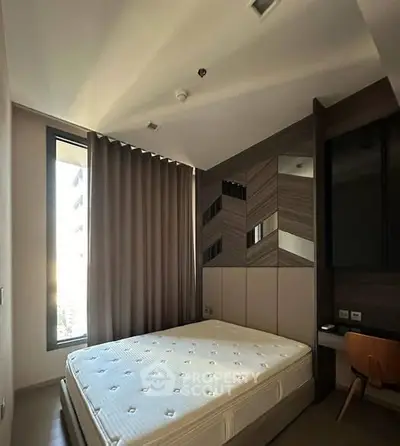 Modern bedroom with stylish decor and large window in a contemporary apartment.
