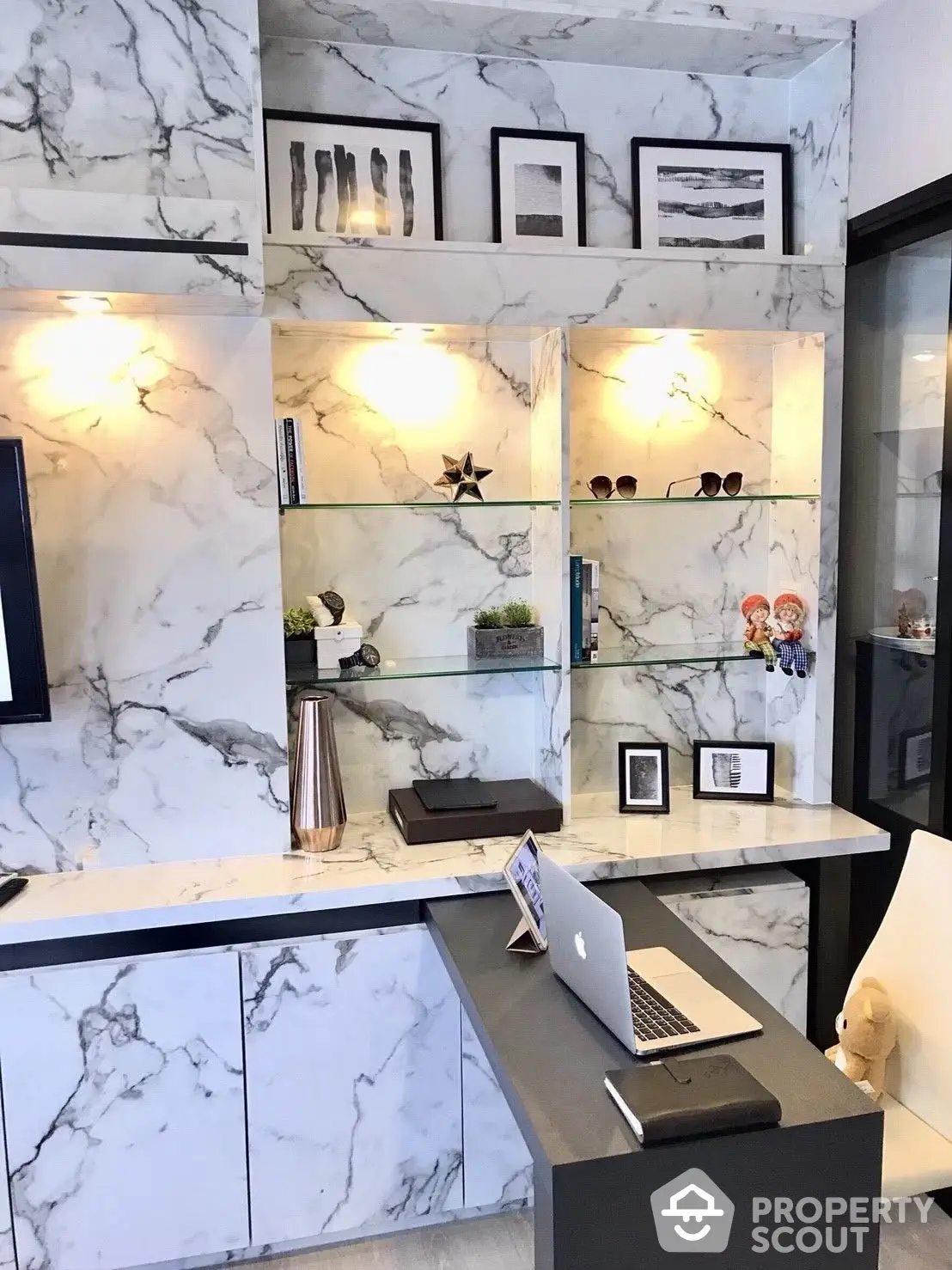 Elegant home office nook with marble walls, modern shelving, and sleek desk design, perfect for productivity and style.