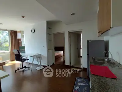 Modern studio apartment with open layout, featuring a compact kitchen and cozy living area with natural light.