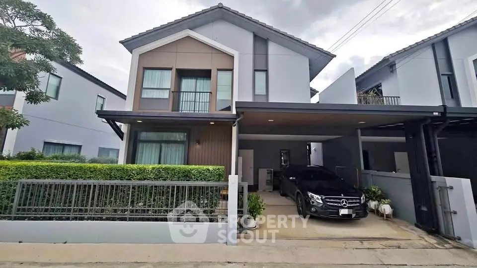 Modern two-story house with carport and sleek exterior design in a suburban neighborhood.